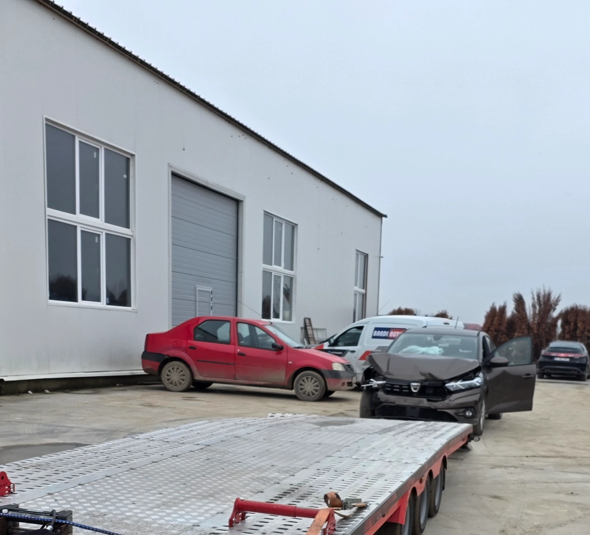 Dacia Logan avariată, încărcată pe platformă