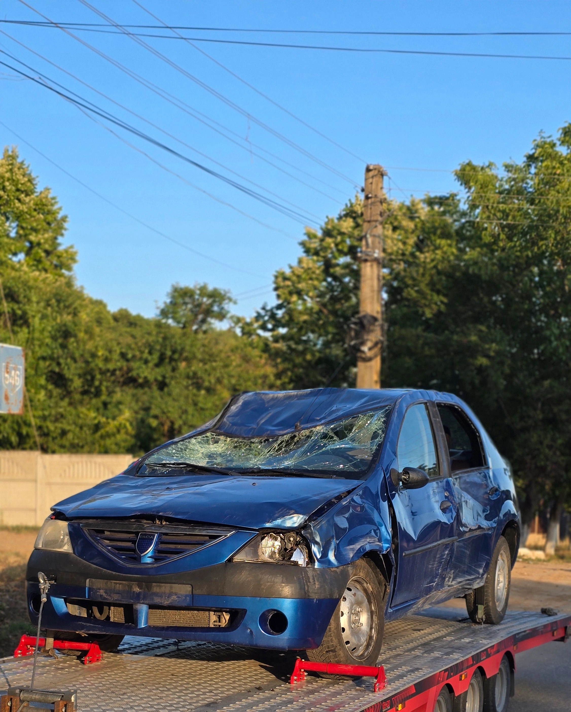 Dacia Logan avariată transportată pe platformă
